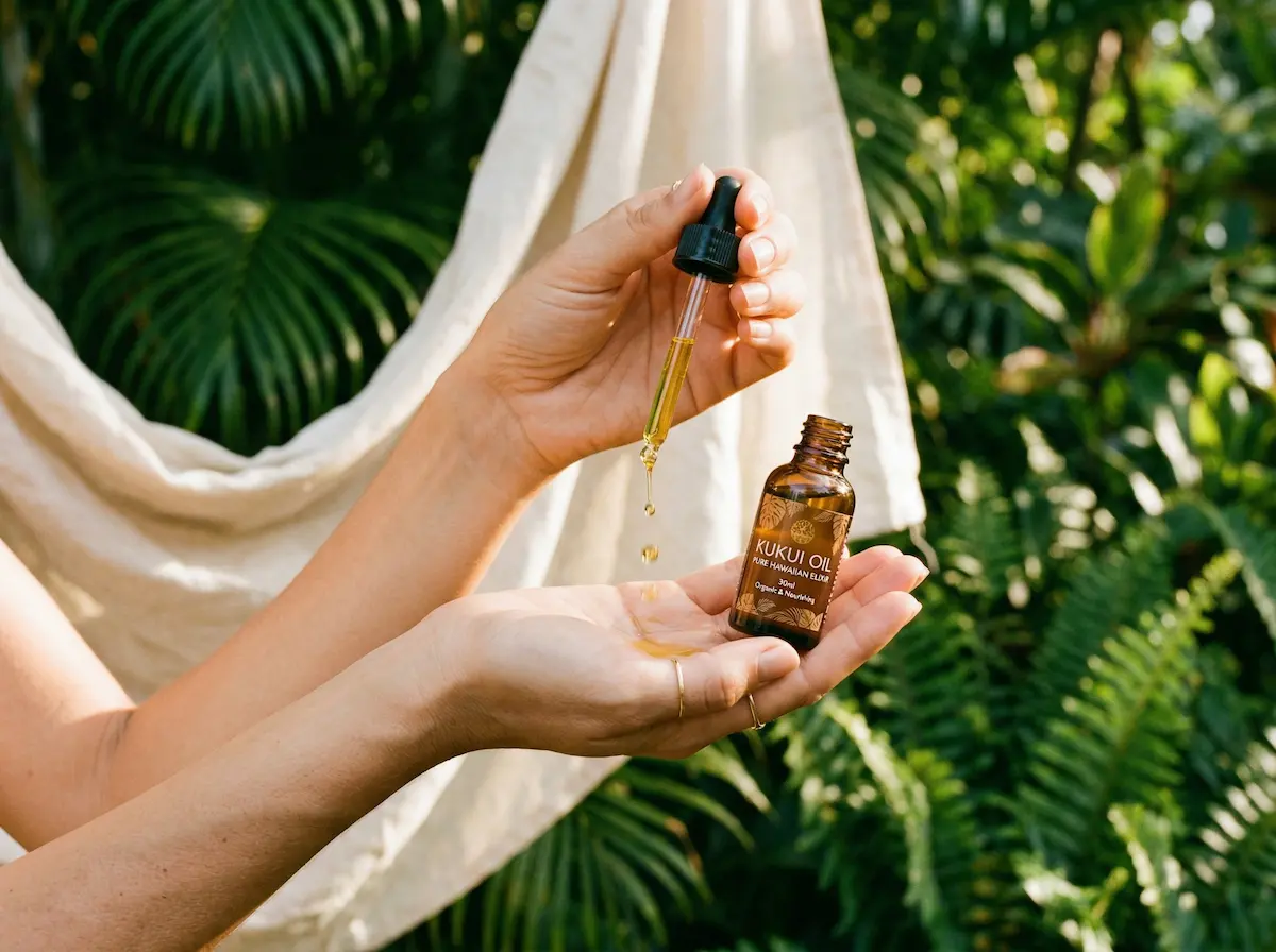 Amber bottle of kukui oil with botanical leaves